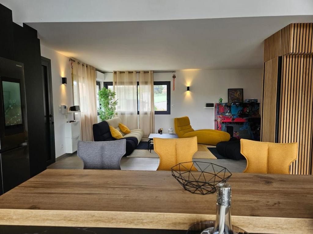 un salon avec une table et des chaises jaunes dans l'établissement sanary villa design piscine calme clim parking, à Sanary-sur-Mer