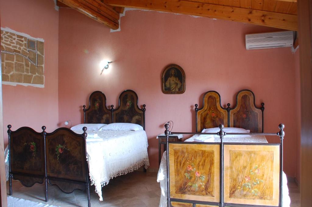 two beds in a room with pink walls at Sa Crannaccia in Càbras