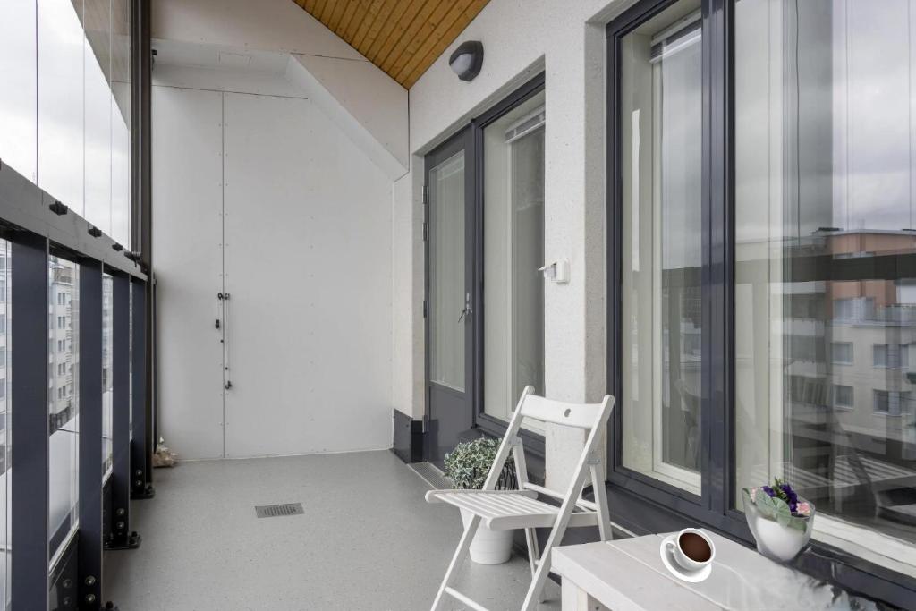 a white chair sitting on a balcony with windows at New Center City Home in Kuopio