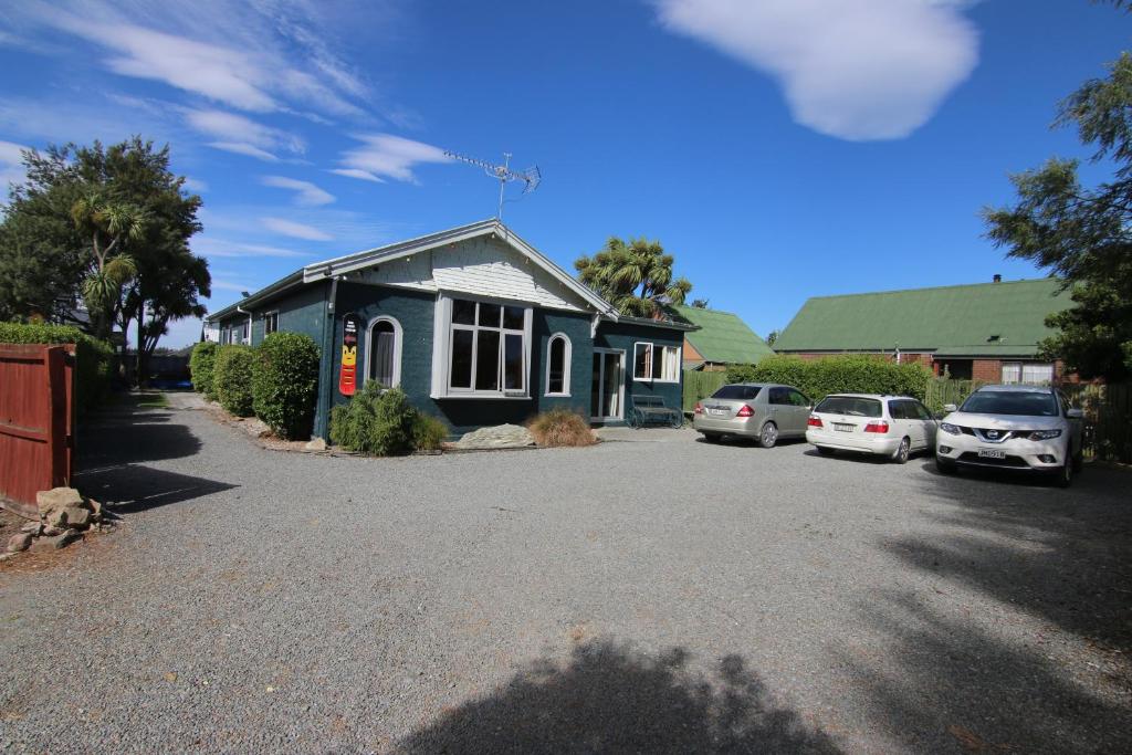 una casa azul con coches aparcados en una entrada en Big Tree Lodge Methven, en Methven