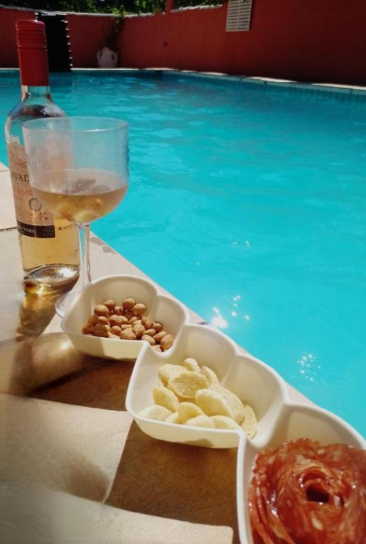 a drink and a tray of food and a glass of wine at Pousada Cantinho do Sagui Inn in Búzios