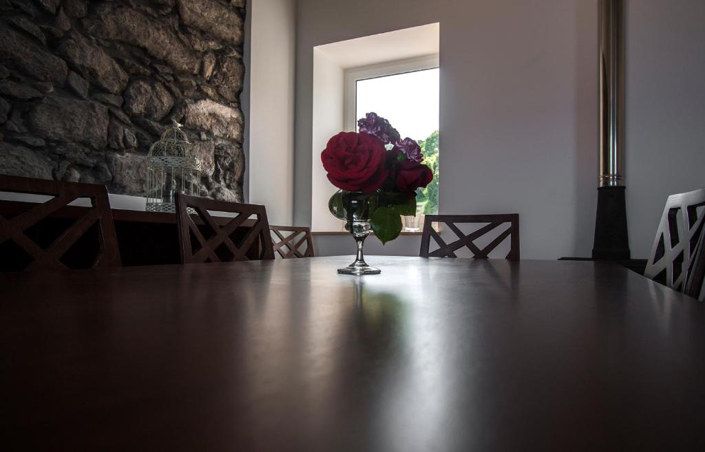 a vase of red roses sitting on top of a table at Casa do Simão in Nordeste