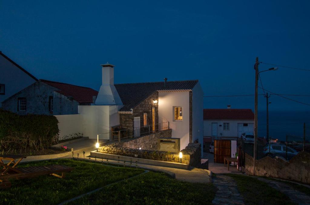a house with lights on the side of it at night at Casa do Simão in Nordeste