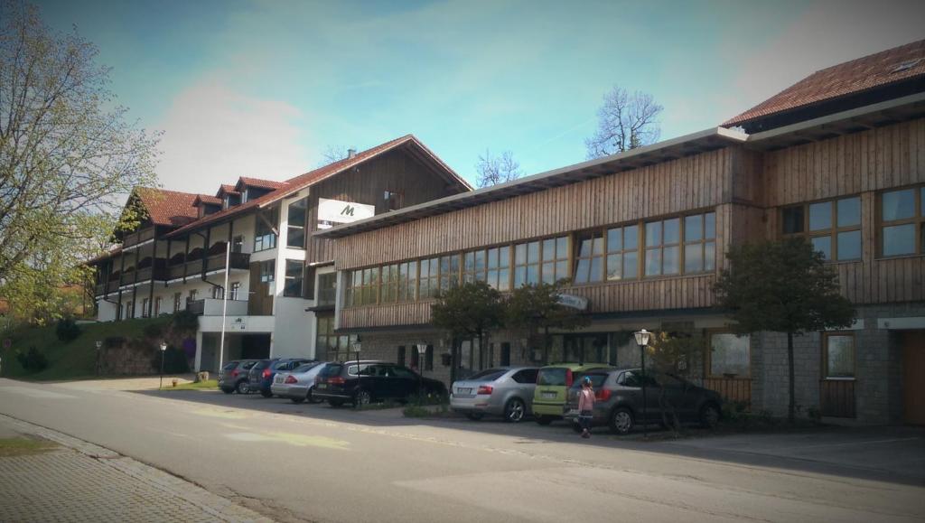 ein großes Gebäude mit davor geparkt in der Unterkunft Apartmány v Bavorském lese in Mitterfirmiansreut
