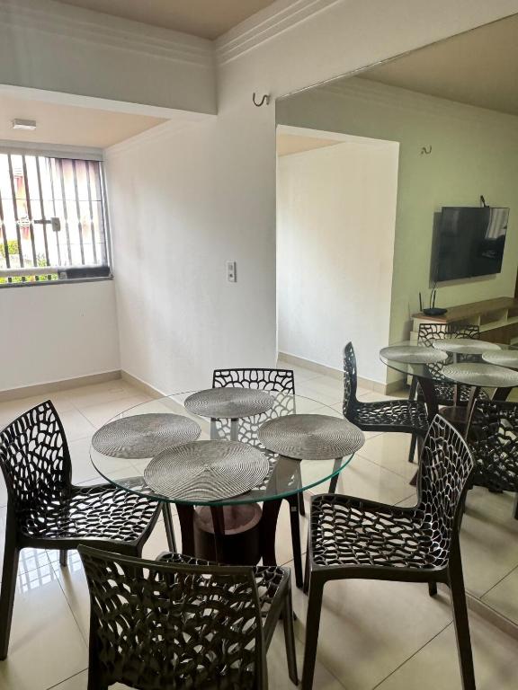 a room with tables and chairs and a flat screen tv at Apê 003 in São Luís