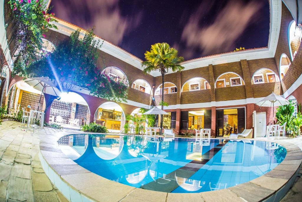 a swimming pool at a hotel at night at Real Pousada in Porto De Galinhas