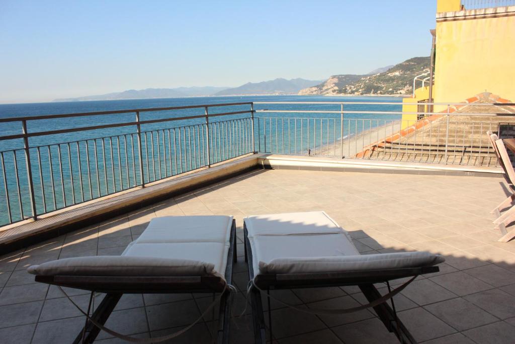 2 sedie e un tavolo sul balcone con vista sull'oceano di Les Agrumes a Varigotti