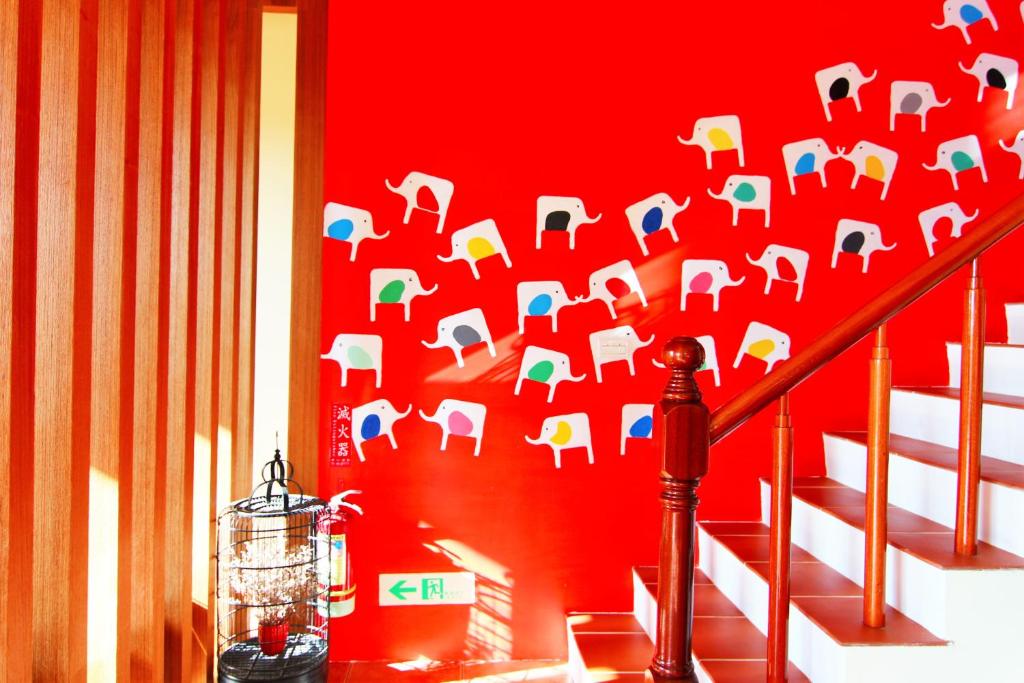 a red wall with an elephant stenciled on it at Ibali Hostel in Magong