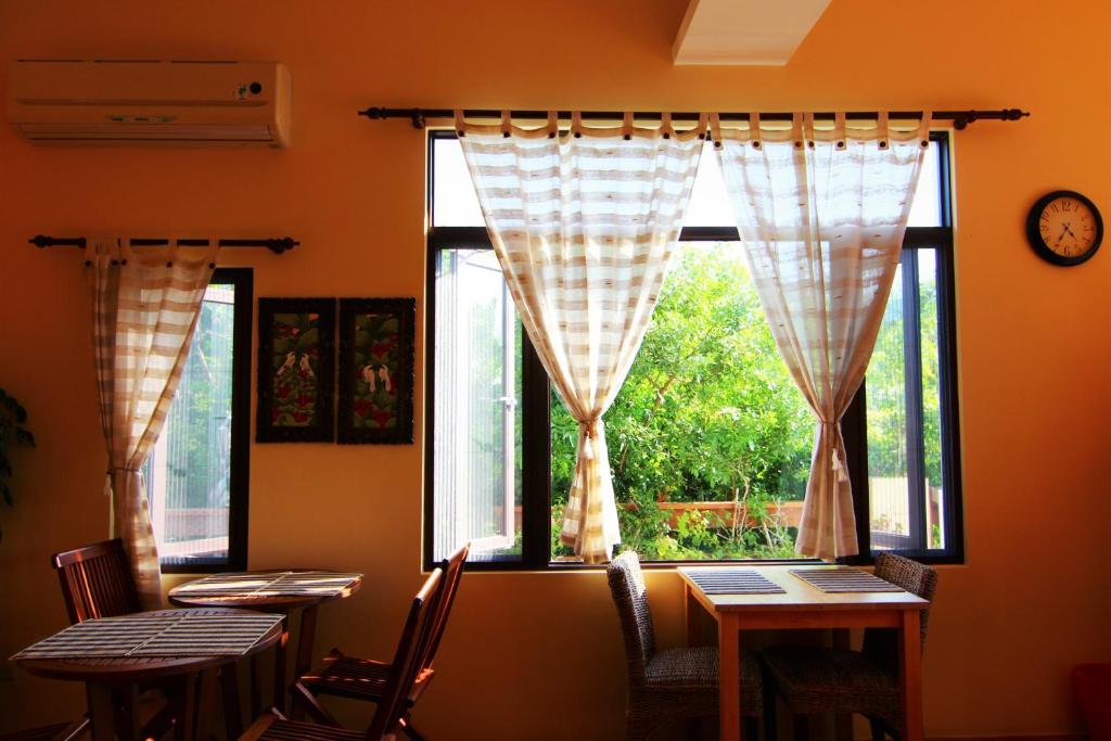 a dining room with two tables and a window at Ibali Hostel in Magong