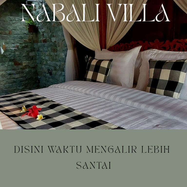 a bedroom with a bed with a black and white comforter at Nabali House in Kerobokan