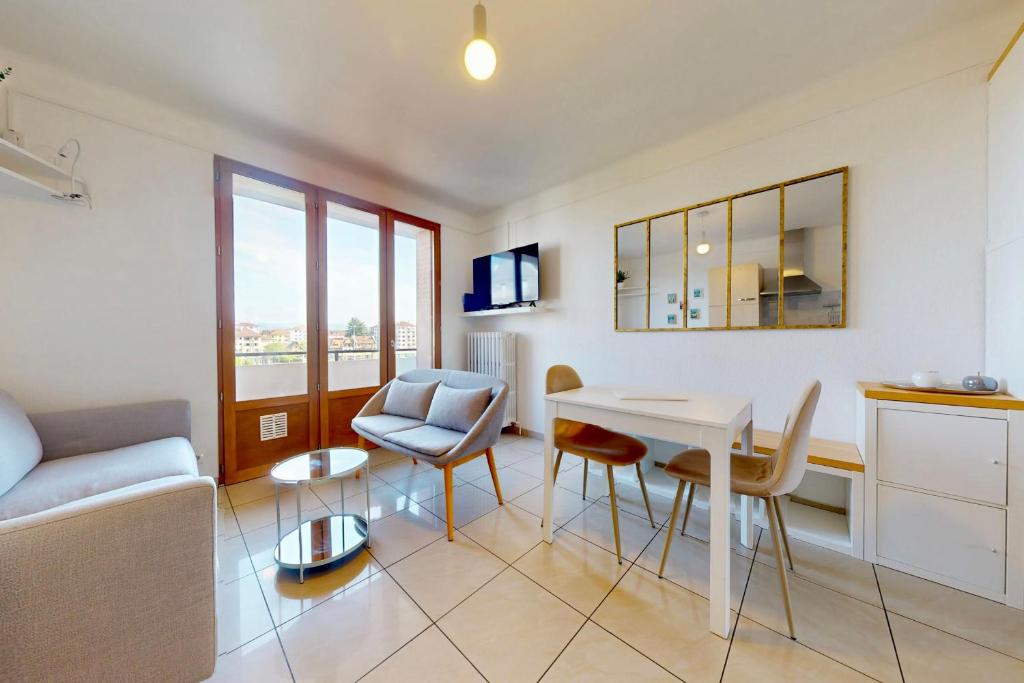 un salon avec une table et des chaises blanches dans l'établissement 3 Quater Avenue de Chevesnes, à Annecy