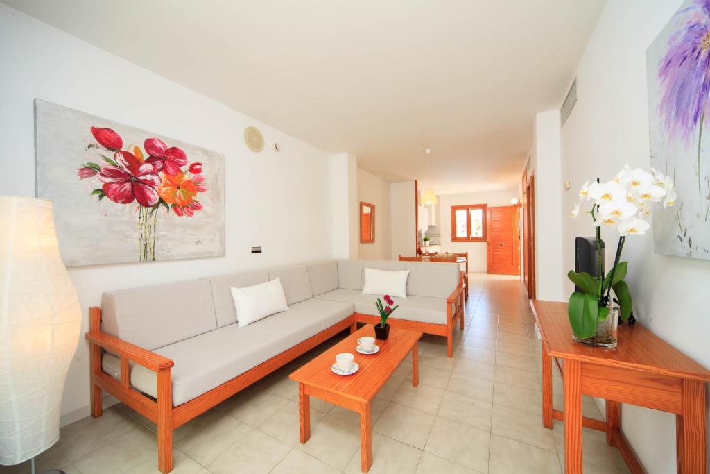 a living room with a white couch and a table at Mar Brava Apartments in Can Picafort