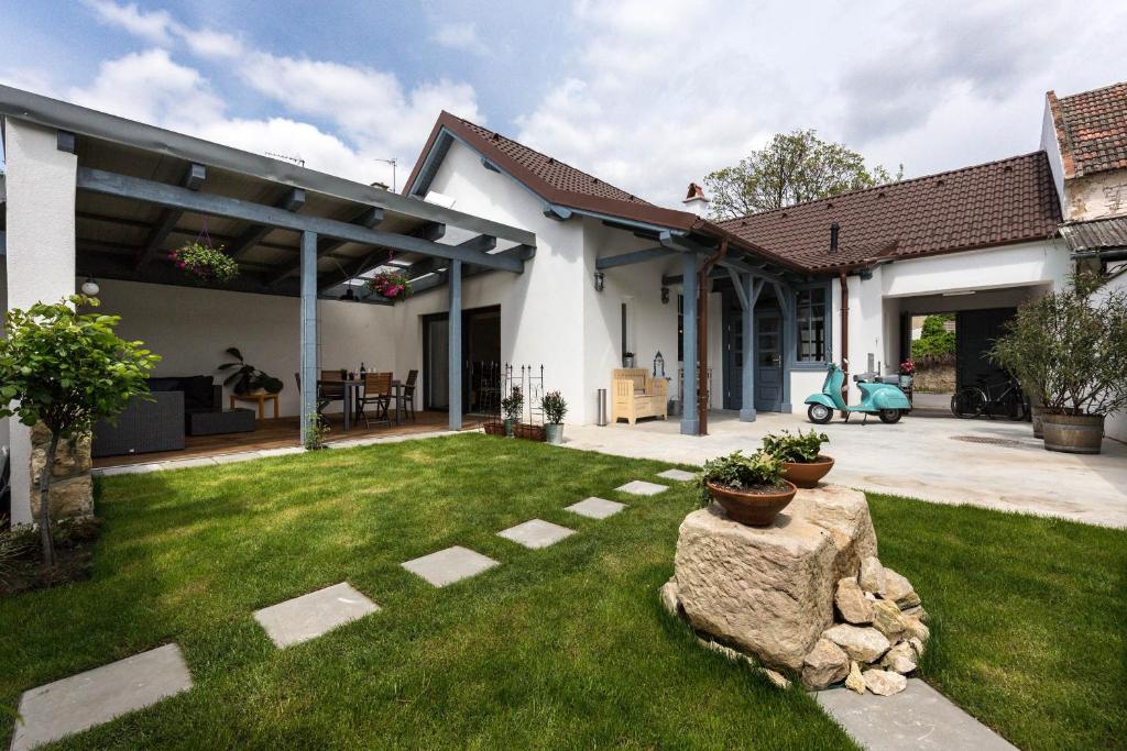 dom z zielonym dziedzińcem z kamienną ścieżką w obiekcie Ferienhaus Burgenland 2 w mieście Mönchhof