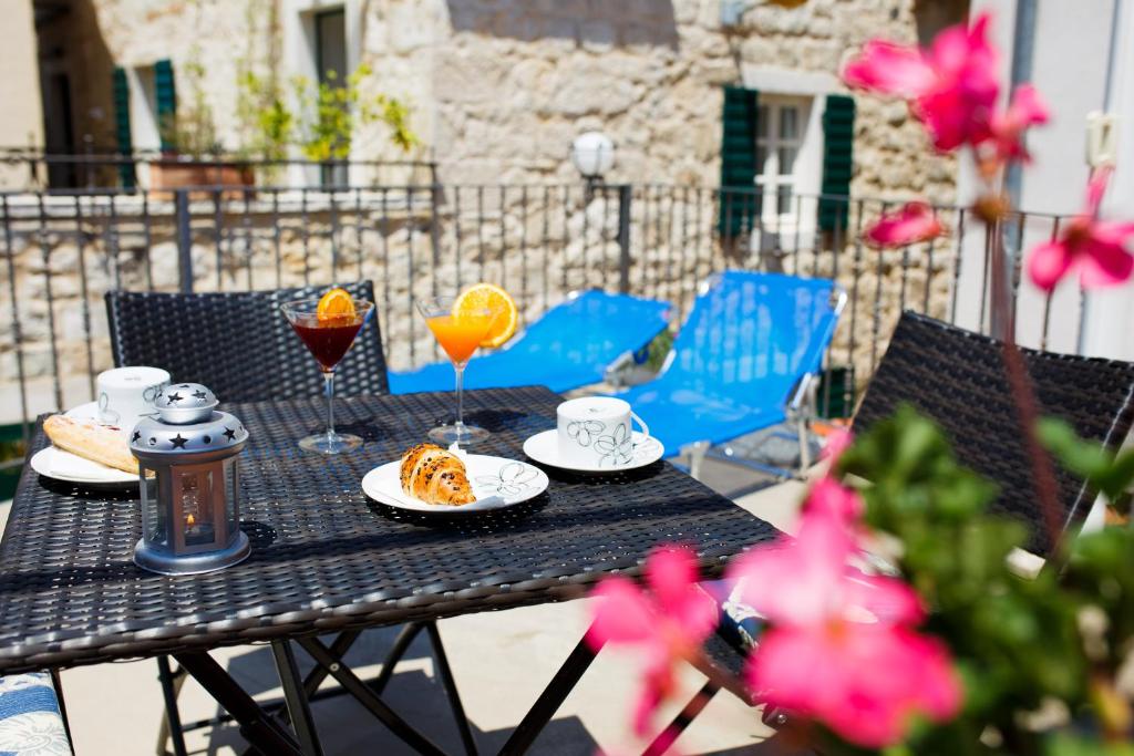 uma mesa preta com pratos de comida e bebidas em Studio Apartments Bonaca em Split