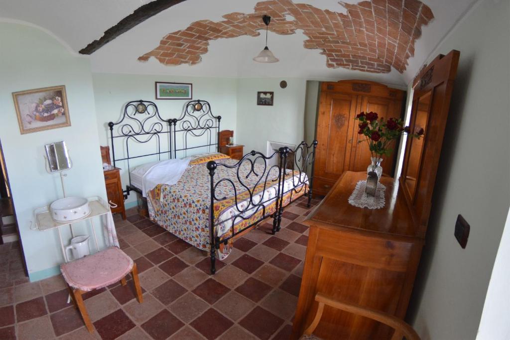 a bedroom with a bed and a table and a chair at B&B Ca' dla Nona in Brusasco