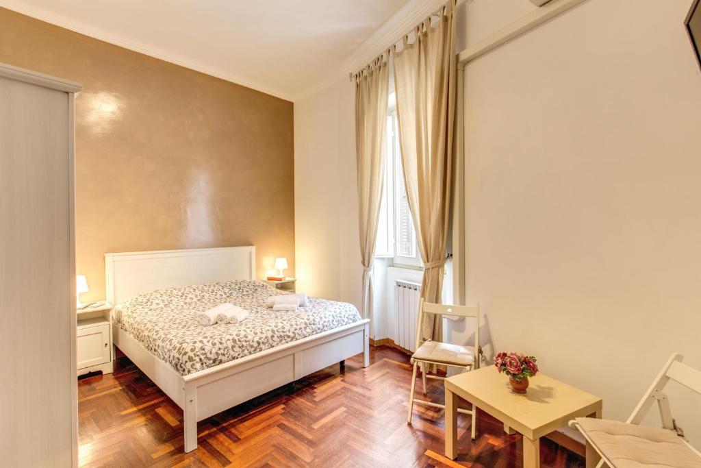 a bedroom with a white bed and a table and chairs at Finally in Rome in Rome