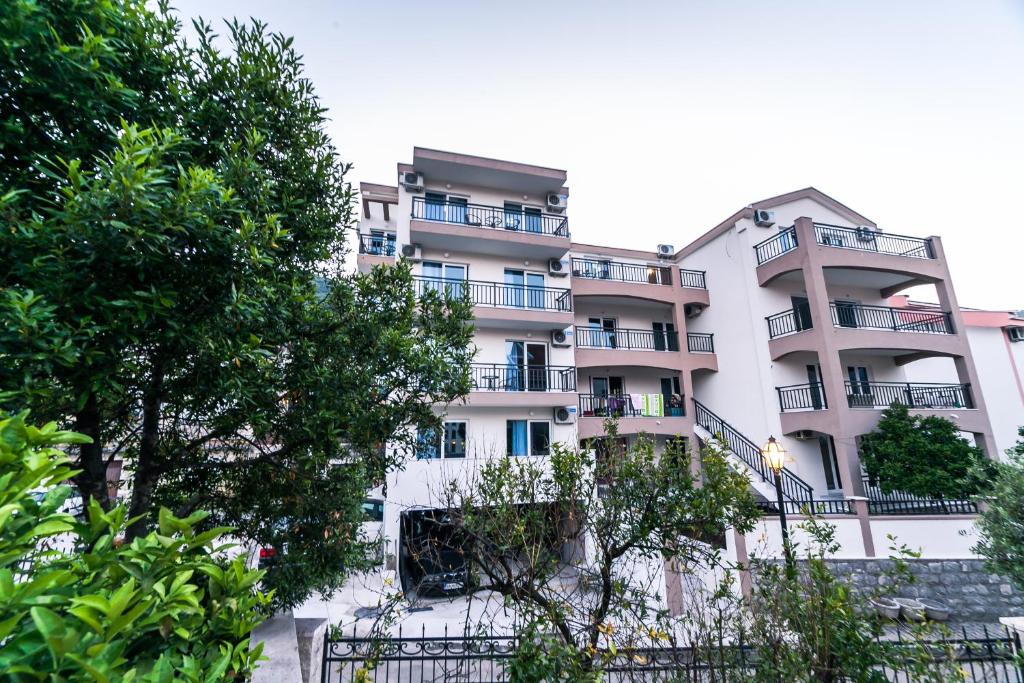 an apartment building with balconies and trees at Milara Apartments in Budva