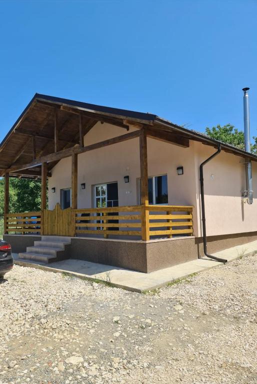 a small house with a porch and a fence at Garden Chalet in Câmpulung