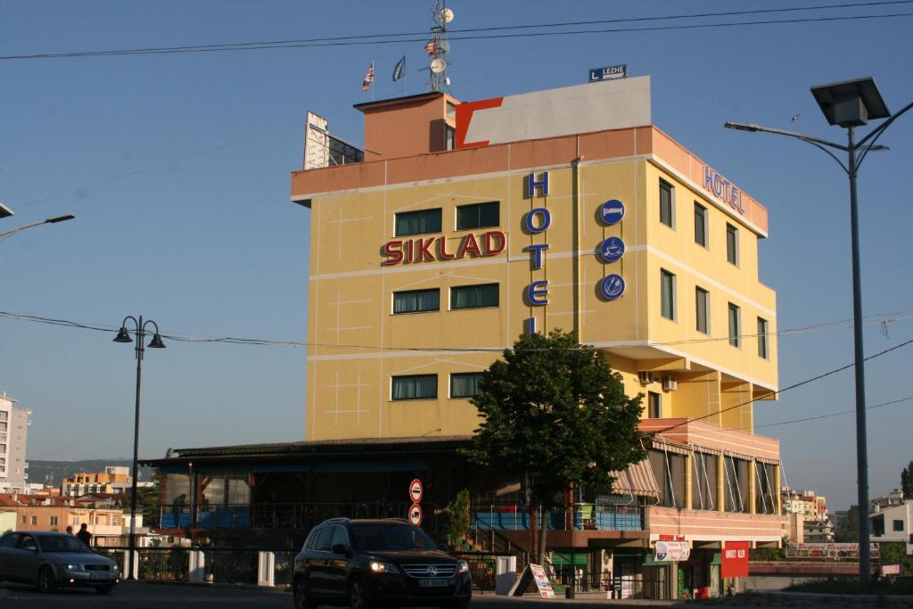 um edifício amarelo com um sinal de skaid em Hotel Siklad em Lezhë