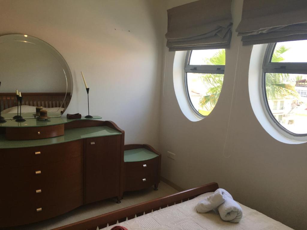 een badkamer met een wastafel, een spiegel en een bed bij Alex Residence in Larnaka