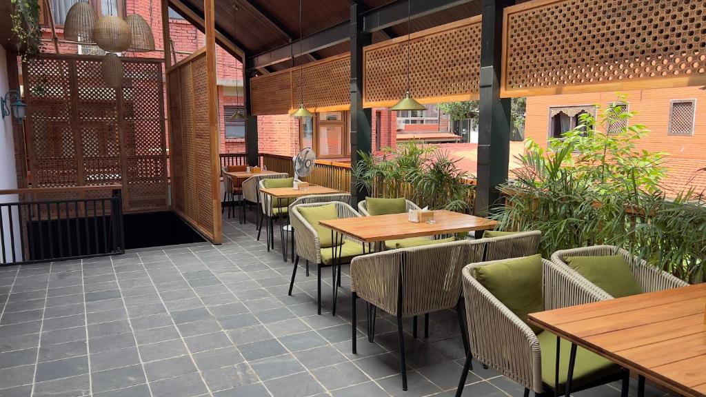 un ristorante con tavoli e sedie in legno in un patio di Hotel Kailash Kutee a Kathmandu