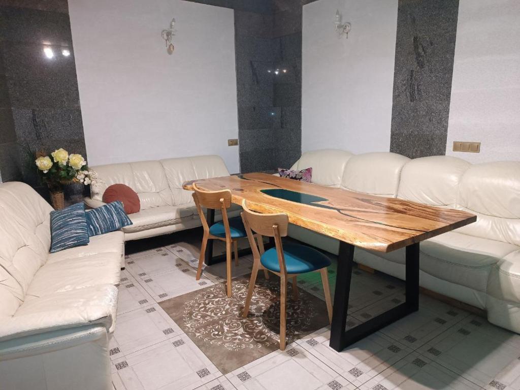 a living room with a wooden table and chairs at Номер у моря, бассейн, сад, мангал in Odesa