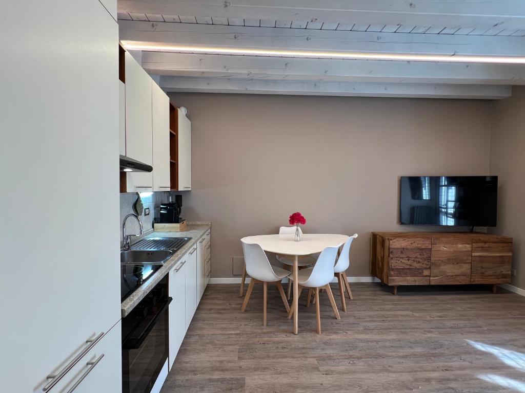 een keuken met een tafel en stoelen en een televisie bij La casa ai Laghetti in Montorio Veronese