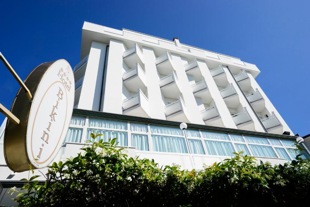 a tall white building with a sign in front of it at Hotel Bikini in Rimini