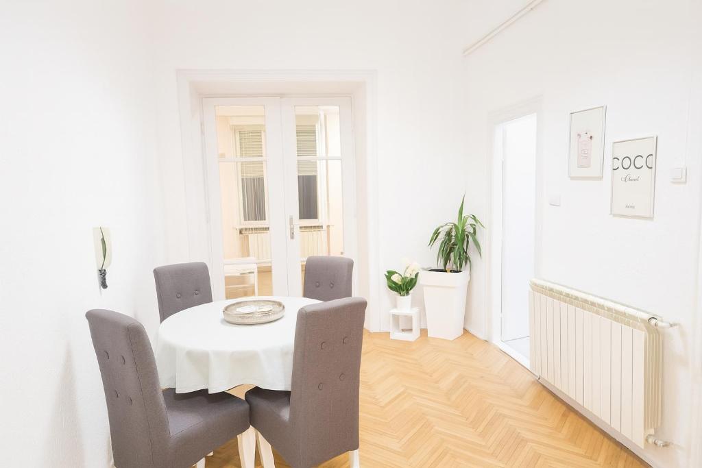 贝尔格莱德ELEGANT STAY-Boutique Apartment Experience的白色的用餐室配有白色的桌椅