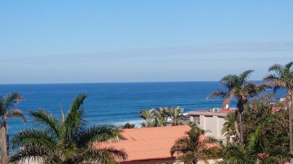 a view of the ocean from a resort at Topanga Holiday Home in Uvongo Beach