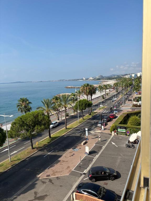 - une vue sur une rue avec une plage et l'océan dans l'établissement Paddock, à Cagnes-sur-Mer