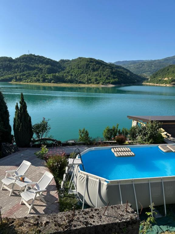 a swimming pool with a view of a lake at Vikendica Plavi Mir in Konjic