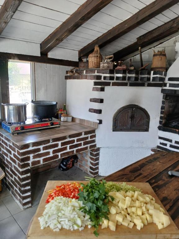 a kitchen with a cutting board with vegetables on a counter at Pensiune Agroturistica Oglinda Lacului in Colibiţa