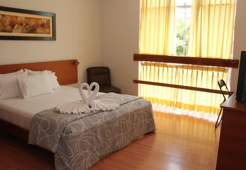 a hotel room with a bed and a television at My Rouse Hotel in Chiclayo