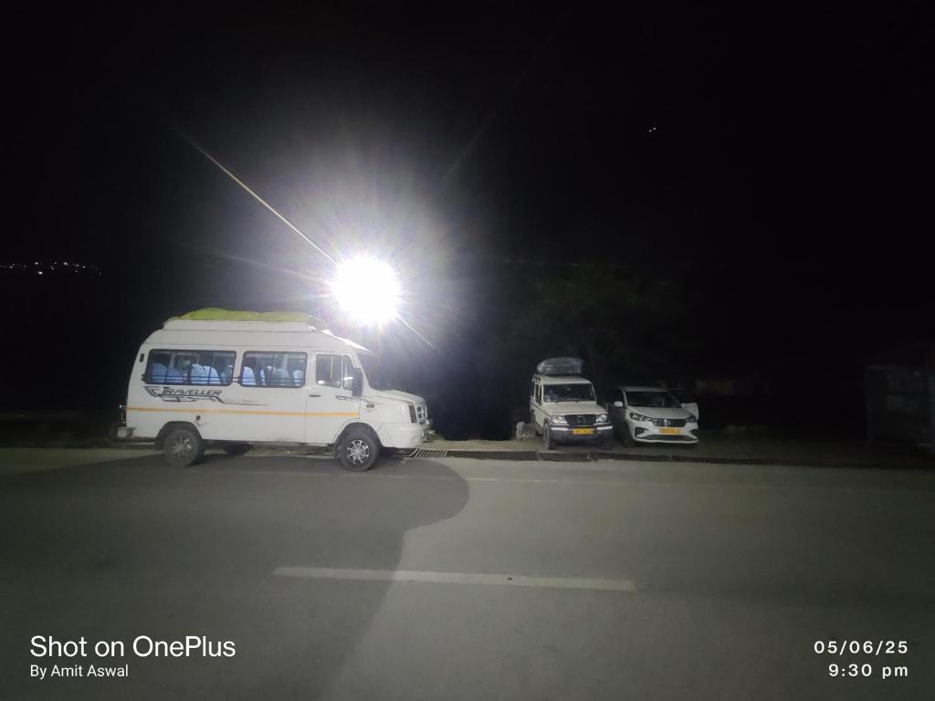 a white van parked under a light at night at Mansi Hotel and restaurant in Chamoli