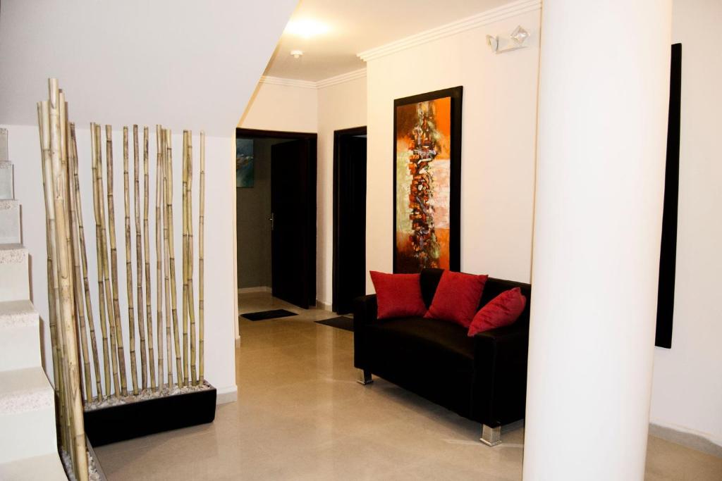 a living room with a black couch and red pillows at Hotel Terra Sur Cuenca in Cuenca