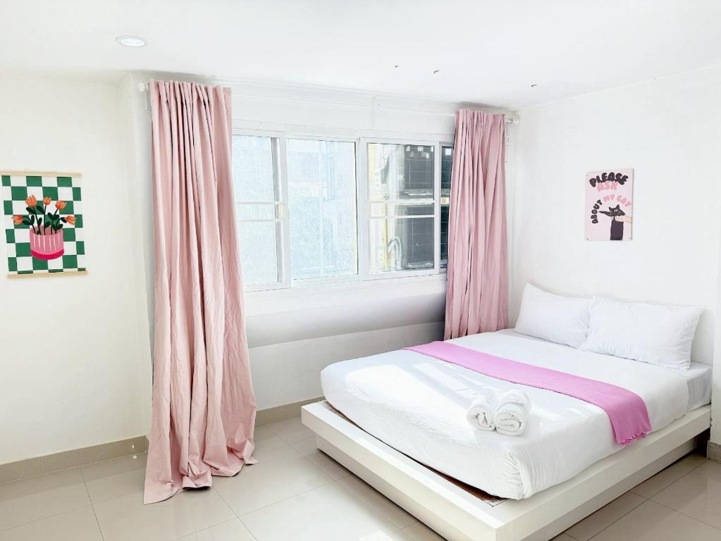 een slaapkamer met een bed met roze gordijnen bij Oh My Nap- Sukhumvit Soi 3 BTS Nana in Bangkok