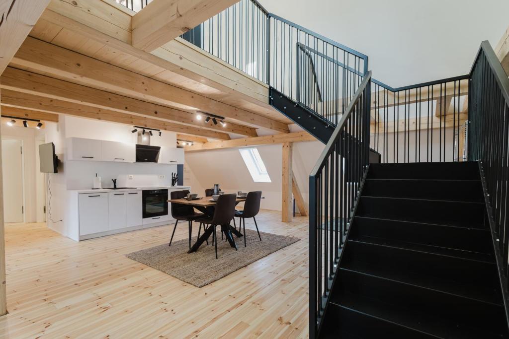 a staircase leading up to a kitchen and a dining room with a table at Stilvolles Wohnen am Ziegeltor - Für Gruppen, Pärchen und Singles in Amberg
