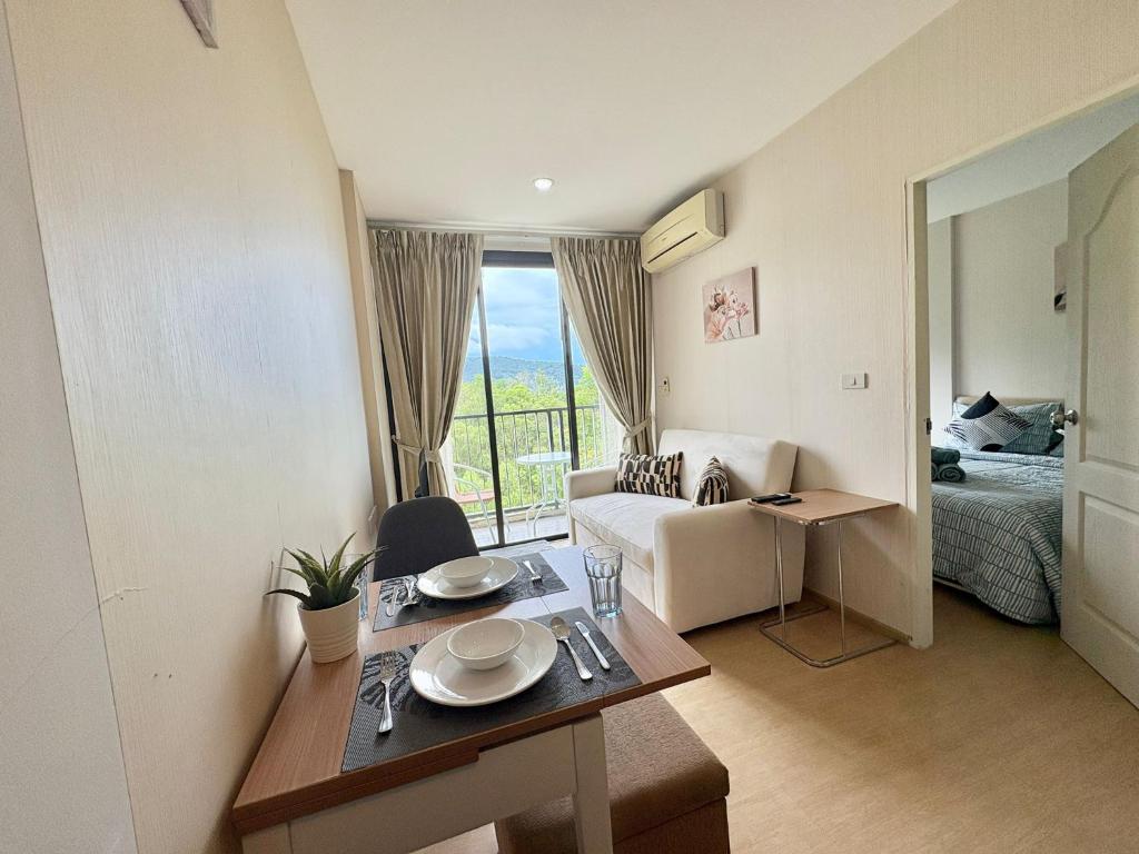 1 dormitorio y sala de estar con mesa de comedor. en Cozy 1 bedroom in prime Bangtao, en Bang Tao Beach