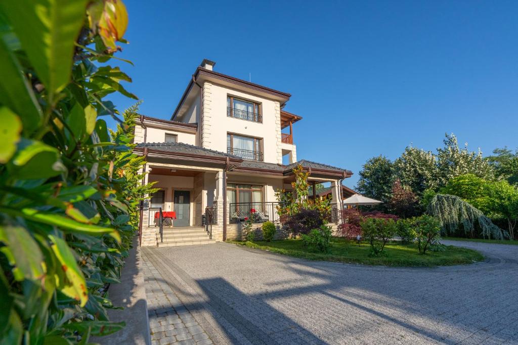 a large house with a driveway in front of it at Casa MT - Boutique Villa in Gabrovo