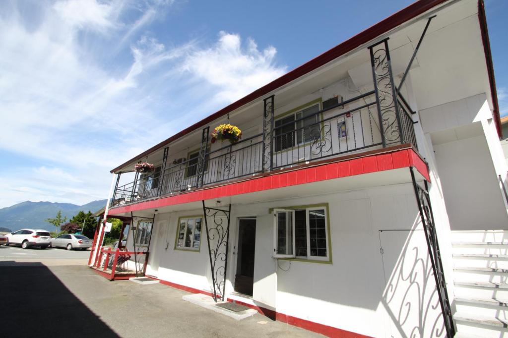 a white building with balconies on the side of it at Harrison Spa Motel in Harrison Hot Springs