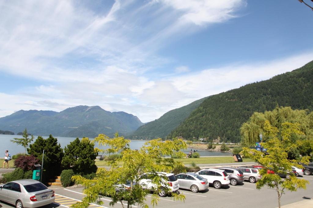 a bunch of cars parked in a parking lot next to a lake at Harrison Spa Motel in Harrison Hot Springs