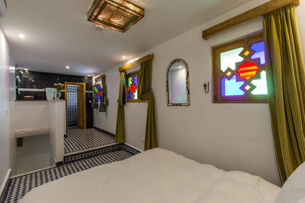 a bedroom with a bed and a window and a bathroom at Riad Amor - Suite & Spa in Fès
