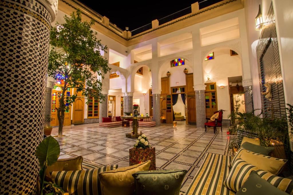 a lobby of a building with couches and trees at Riad Amor - Suite & Spa in Fez