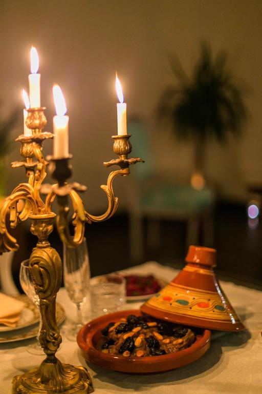 a table with two candles and a plate of food at Riad Amor - Suite & Spa in Fès
