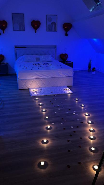 a bedroom with a bed with lights on the floor at Spa home, Hammam in Prénouvellon