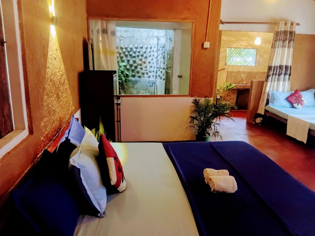 Un dormitorio con una cama y un espejo en una habitación. en Ancient Gardens Villa, en Pinnawala