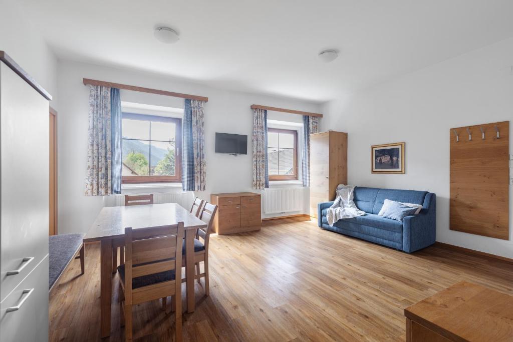 een woonkamer met een tafel en een blauwe bank bij Alte Schule in Rattendorf