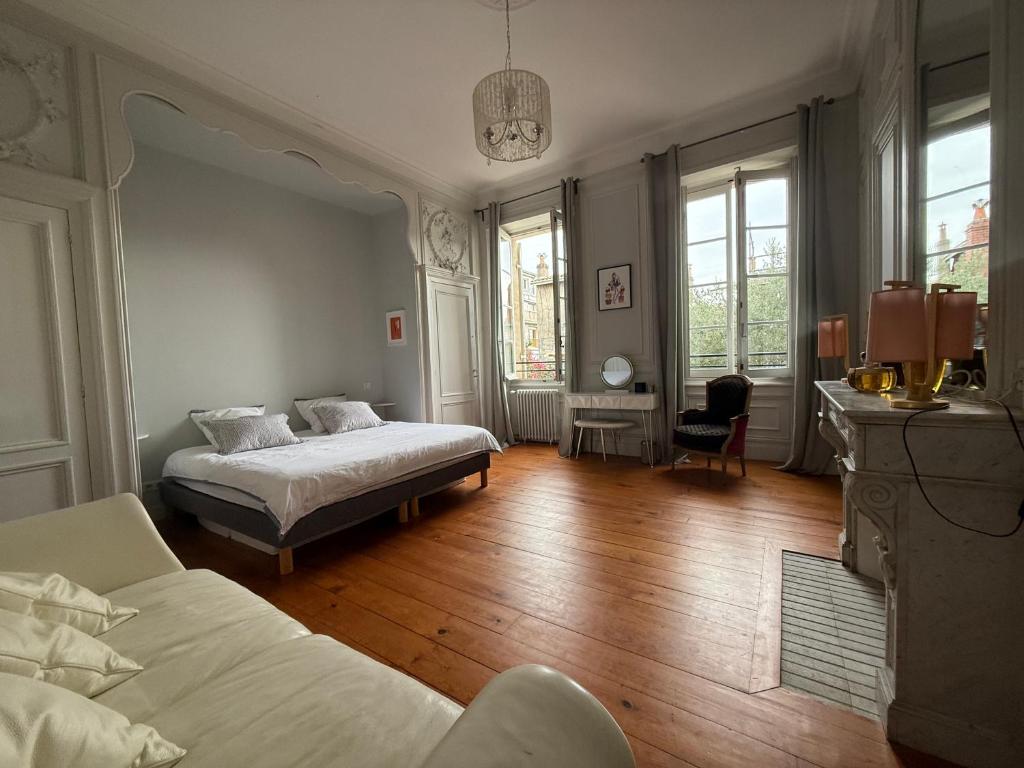 una camera da letto con due letti e uno specchio di La villa du Consulat - Hôtel Particulier - Ascenseur - piscine - Bordeaux a Bordeaux
