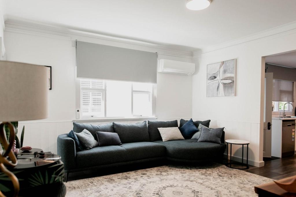 Una sala de estar con un sofá negro en una habitación. en Newdegate St North Hobart, en Hobart